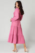 Woman wearing a pink dress on a plain background