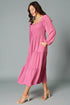 Woman wearing a pink dress against a gray background