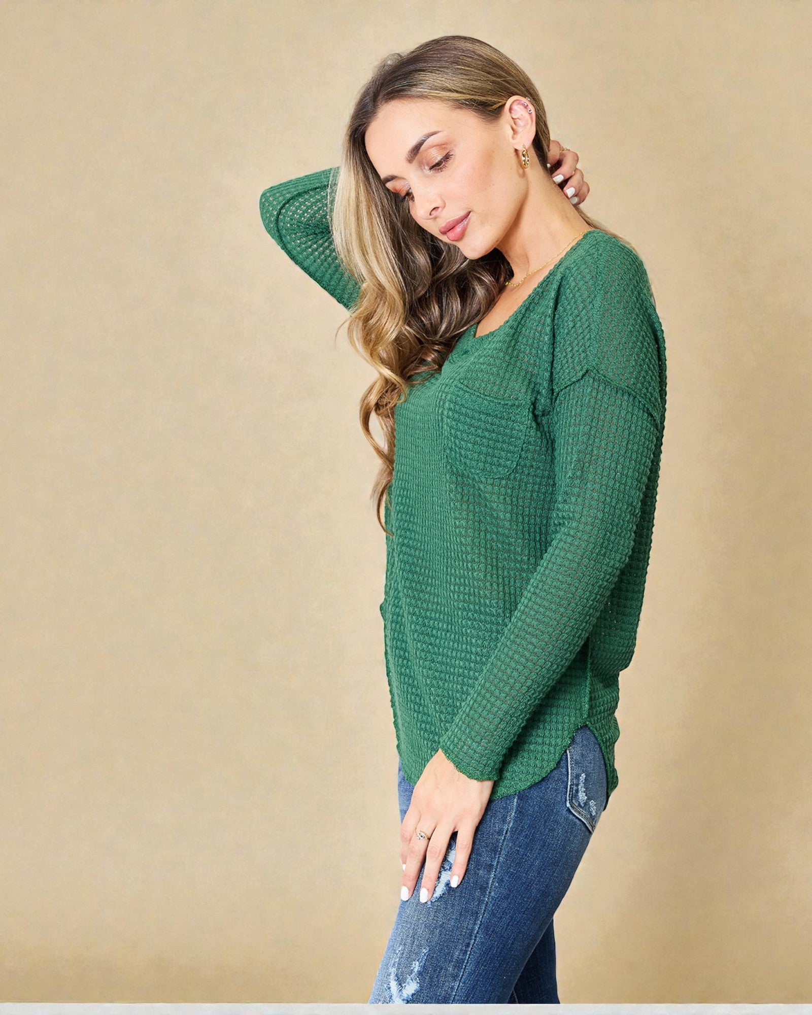 Woman wearing a green sweater against a beige background