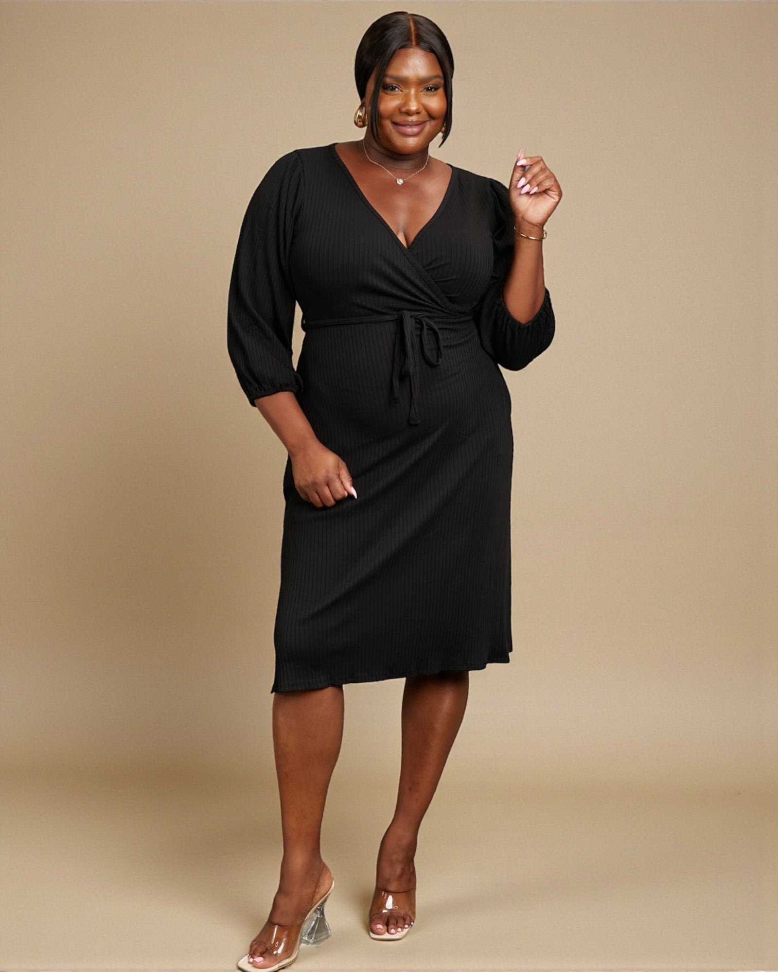 Woman wearing a black dress against a beige background