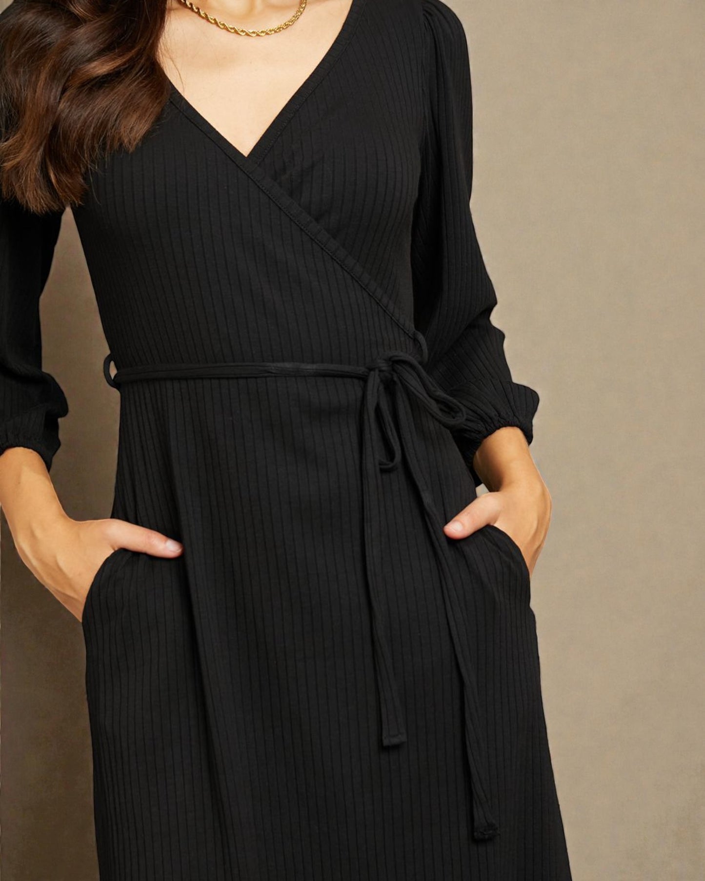 Black ribbed dress worn by a person on a beige background