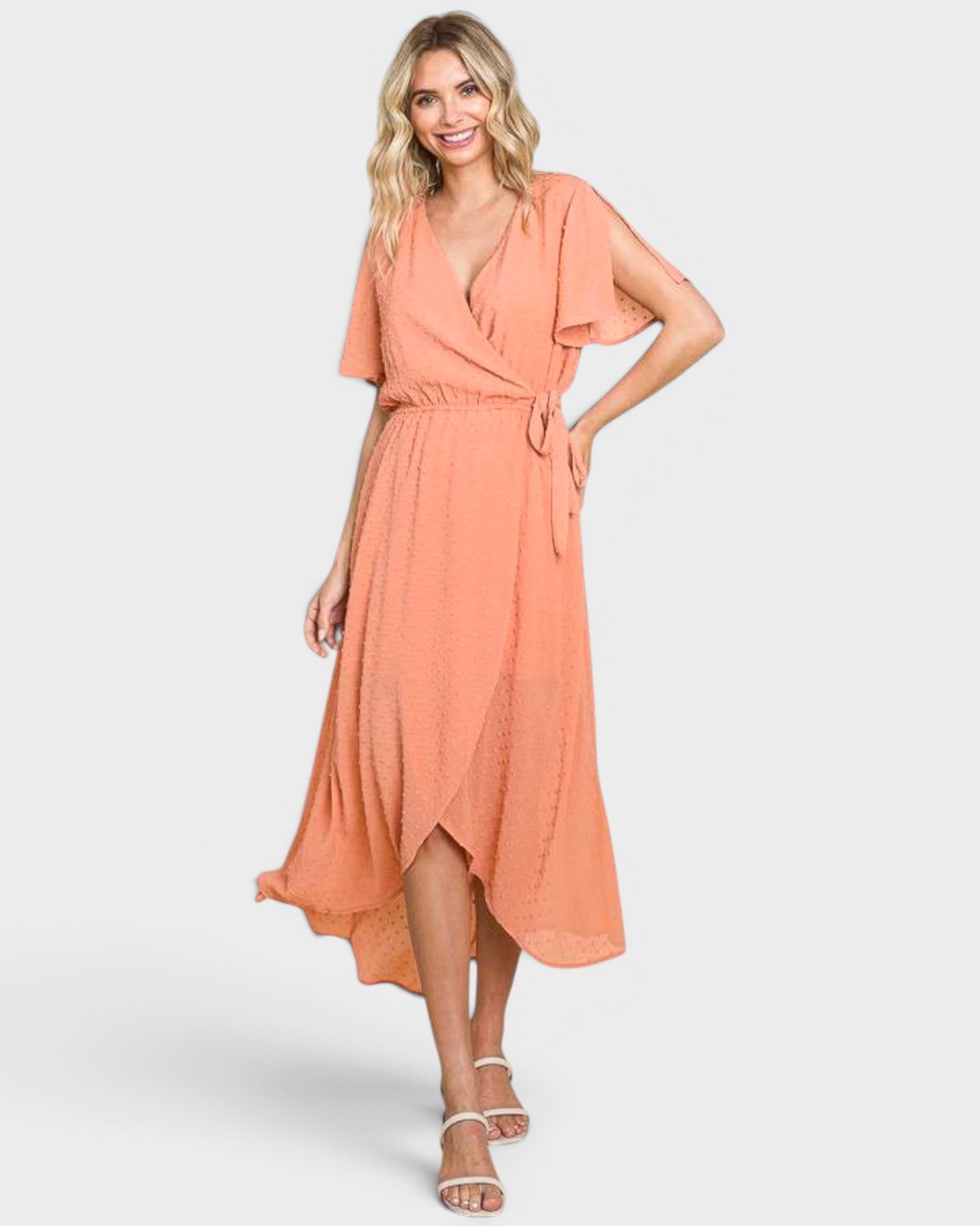 Woman wearing a peach-colored dress on a white background