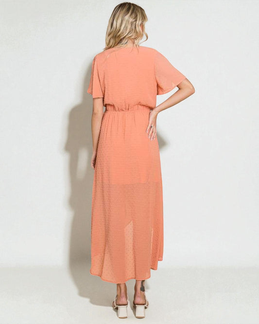 Woman wearing a peach-colored dress on a white background