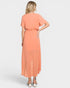 Woman wearing a peach-colored dress on a white background