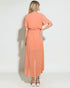 Woman wearing a peach-colored dress on a white background