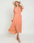 Woman wearing a peach dress and hat on a white background