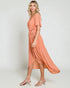 Woman wearing a peach-colored dress on a white background