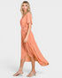 Woman wearing a peach-colored dress on a white background