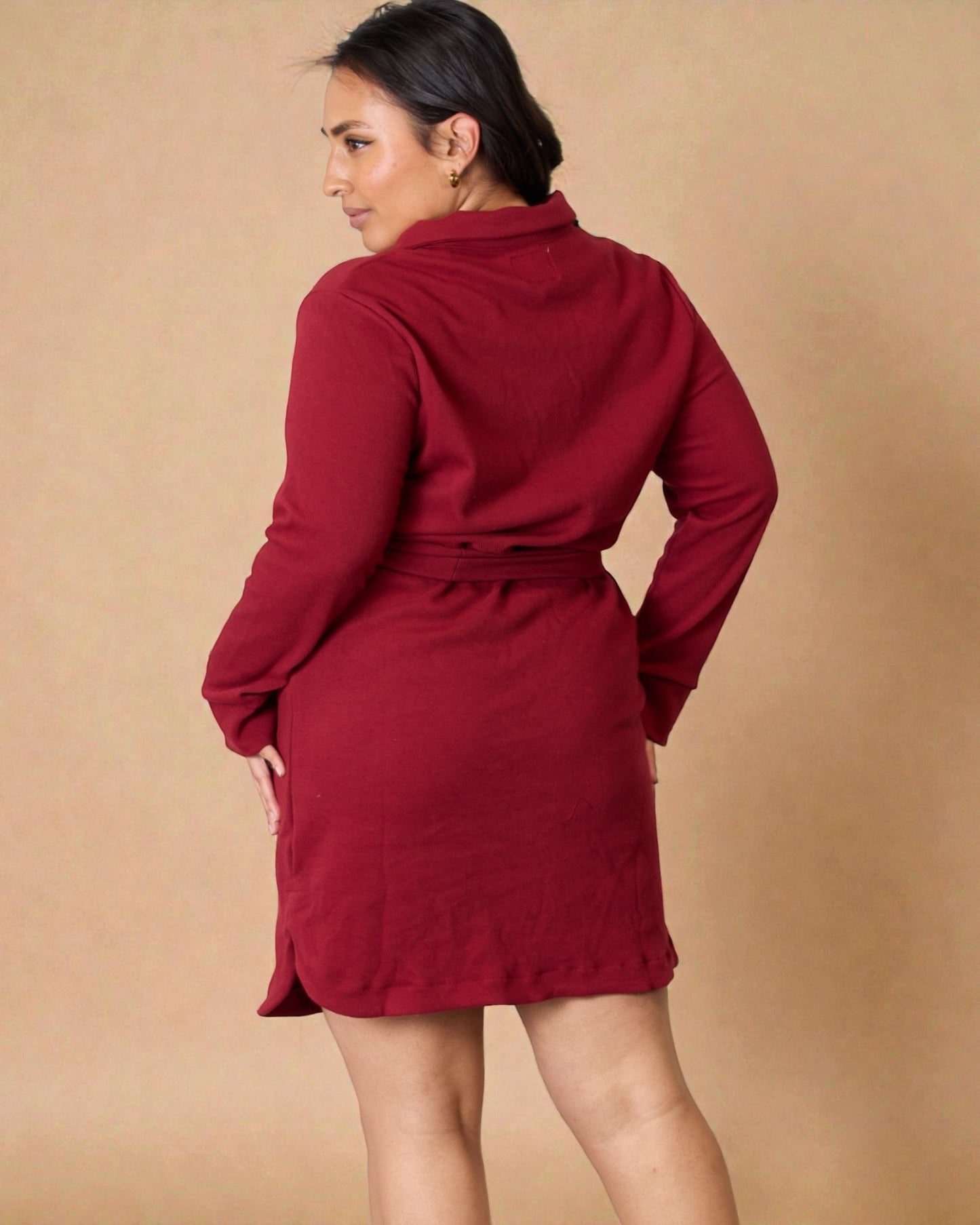 Woman wearing a red dress against a beige background