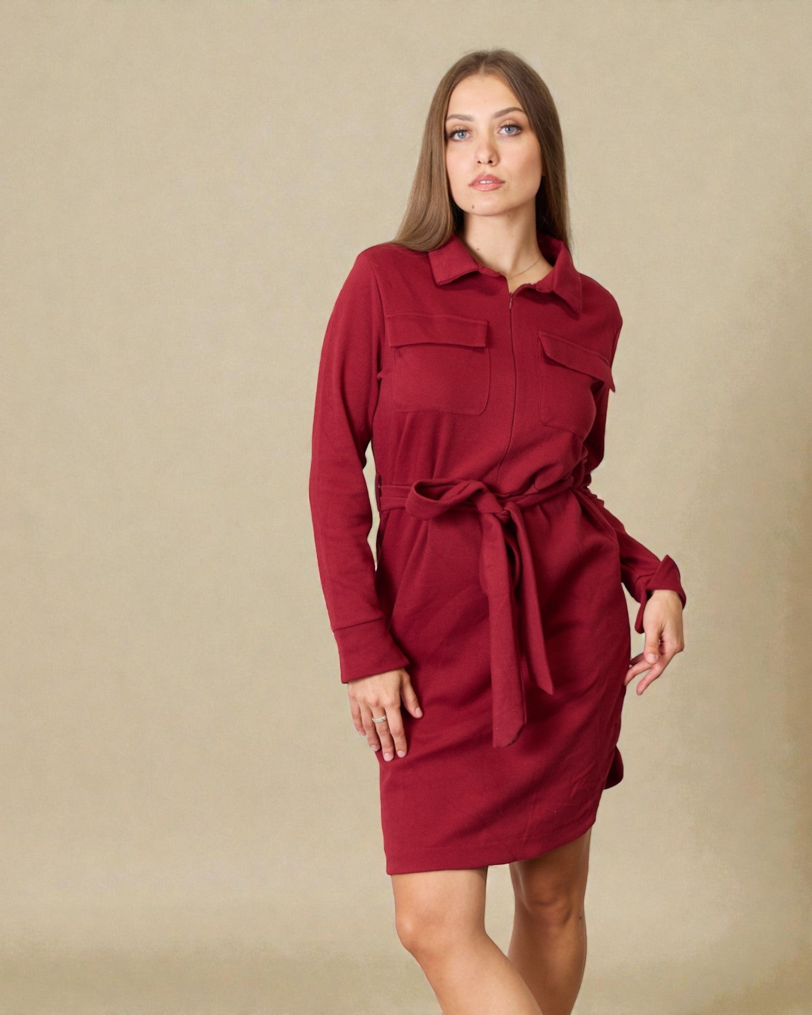 Woman wearing a red dress against a beige background