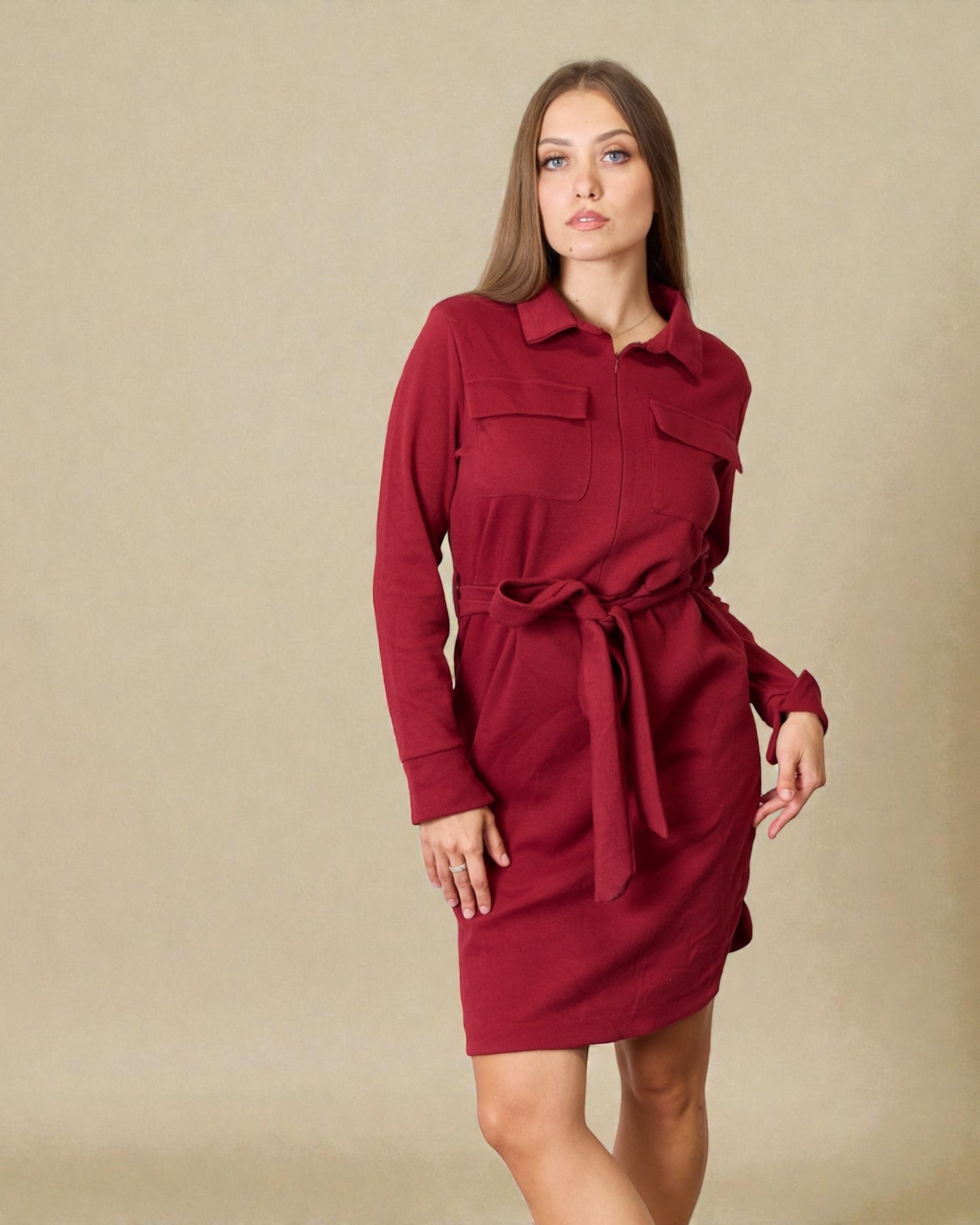 Woman wearing a red dress against a beige background