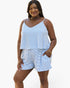 A woman modeling a matching two-piece loungewear set featuring a blue and white striped camisole top and shorts, set against a plain white background.