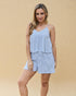 Woman wearing a blue and white striped romper against a beige background