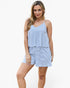 A woman modeling a light blue and white striped two-piece romper set against a plain white studio background.
