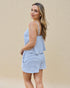 Woman wearing a blue and white striped romper against a beige background