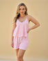 Woman wearing a pink striped pajama set against a beige background
