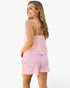 A woman modeling a pink and white striped two-piece lounge set, featuring a camisole top with thin straps and matching shorts, shown from a three-quarters back view against a plain white background.
