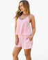 A woman modeling a pink and white striped two-piece set consisting of a sleeveless camisole top and matching shorts, set against a plain white background.