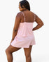 A woman modeling a pink and white striped camisole and shorts set, shown from a back-three-quarter view against a plain light background.