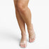 A close-up of a model's legs wearing clear, transparent strap slide sandals with square toes on a light gray studio background.