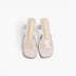 A pair of women's heeled mule sandals with clear transparent straps, a pale pink insole, and a silver glittery square toe cap, shown from a top-down view on a white background.