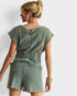 Woman wearing a green romper against a white background