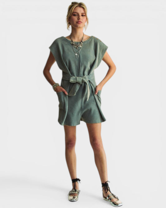 Woman wearing a green dress with a belt on a white background