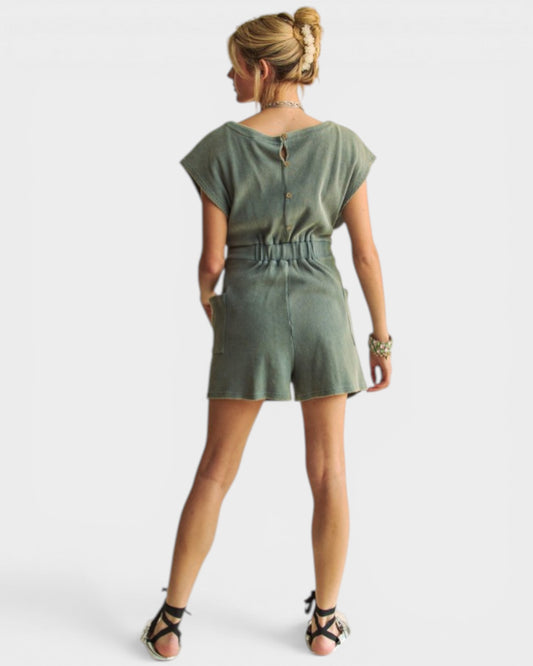 Woman wearing a green romper on a white background