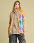 Woman wearing a colorful argyle cardigan over a plaid shirt on a beige background