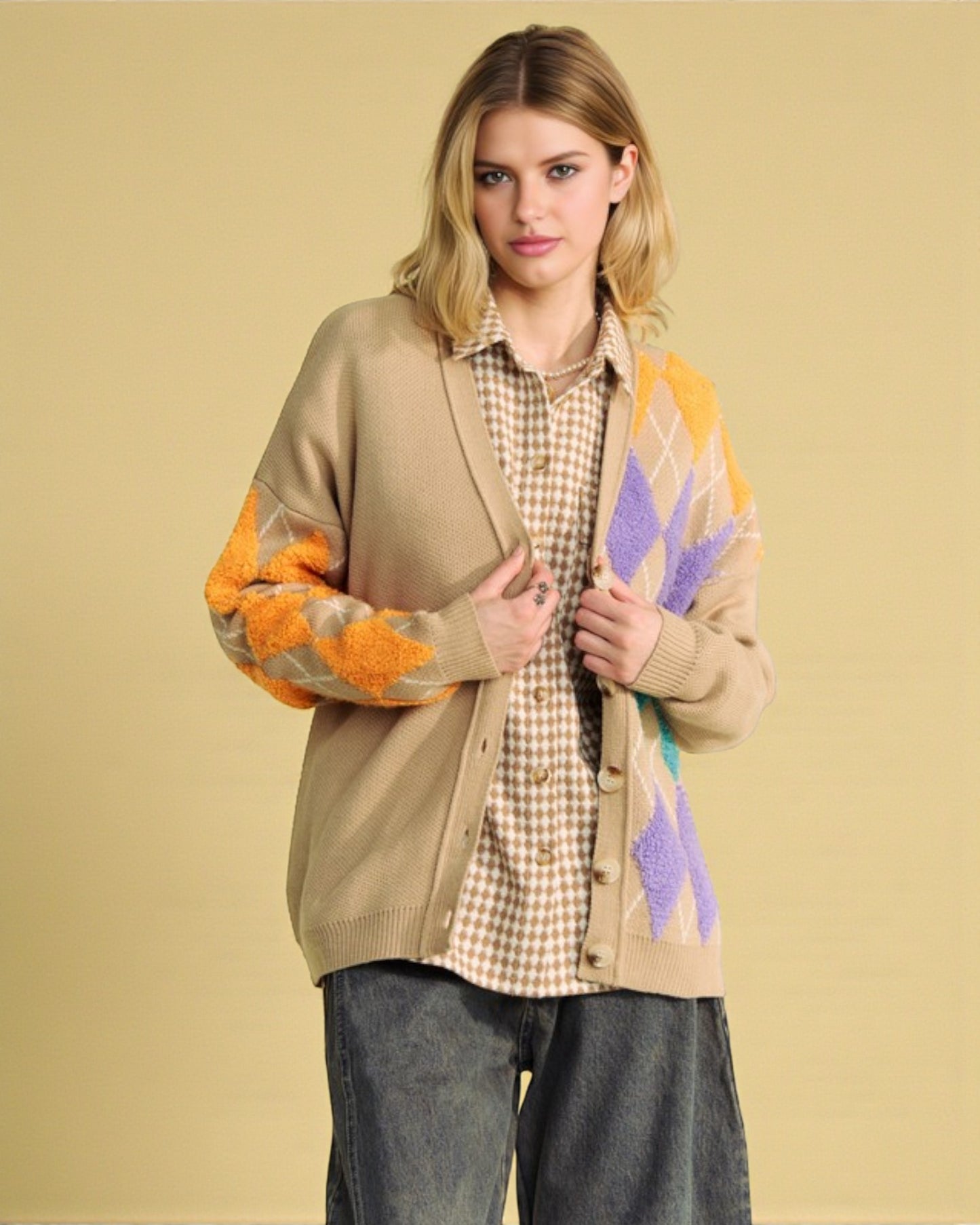 Woman wearing a beige cardigan with colorful pattern on a beige background