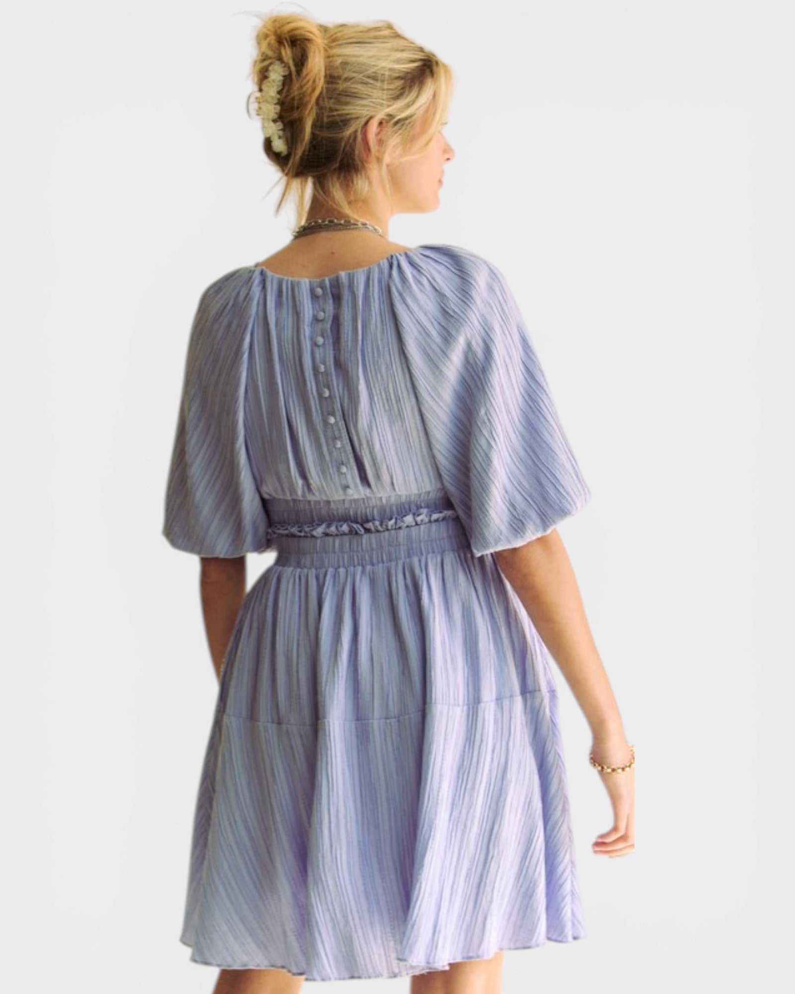 Woman wearing a light purple striped dress on a white background