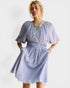 Woman wearing a light blue dress with puffed sleeves against a white background