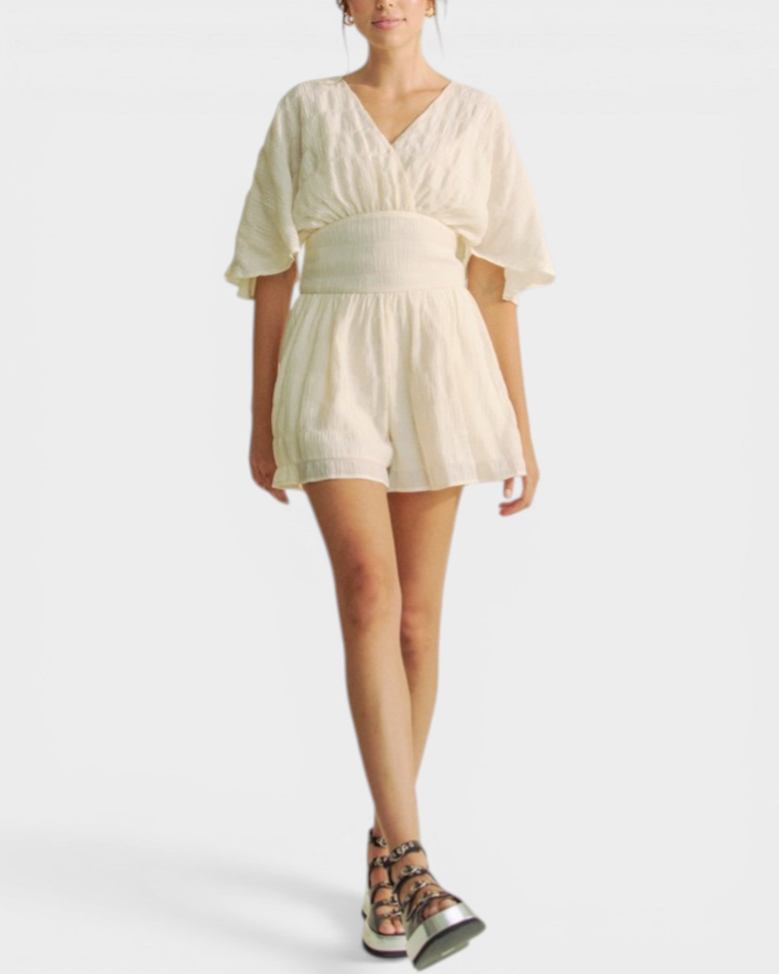 Woman wearing a light-colored dress on a white background