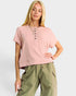 Woman wearing a pink top and green pants on a white background