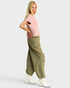 Woman wearing a pink top and green cargo pants on a white background