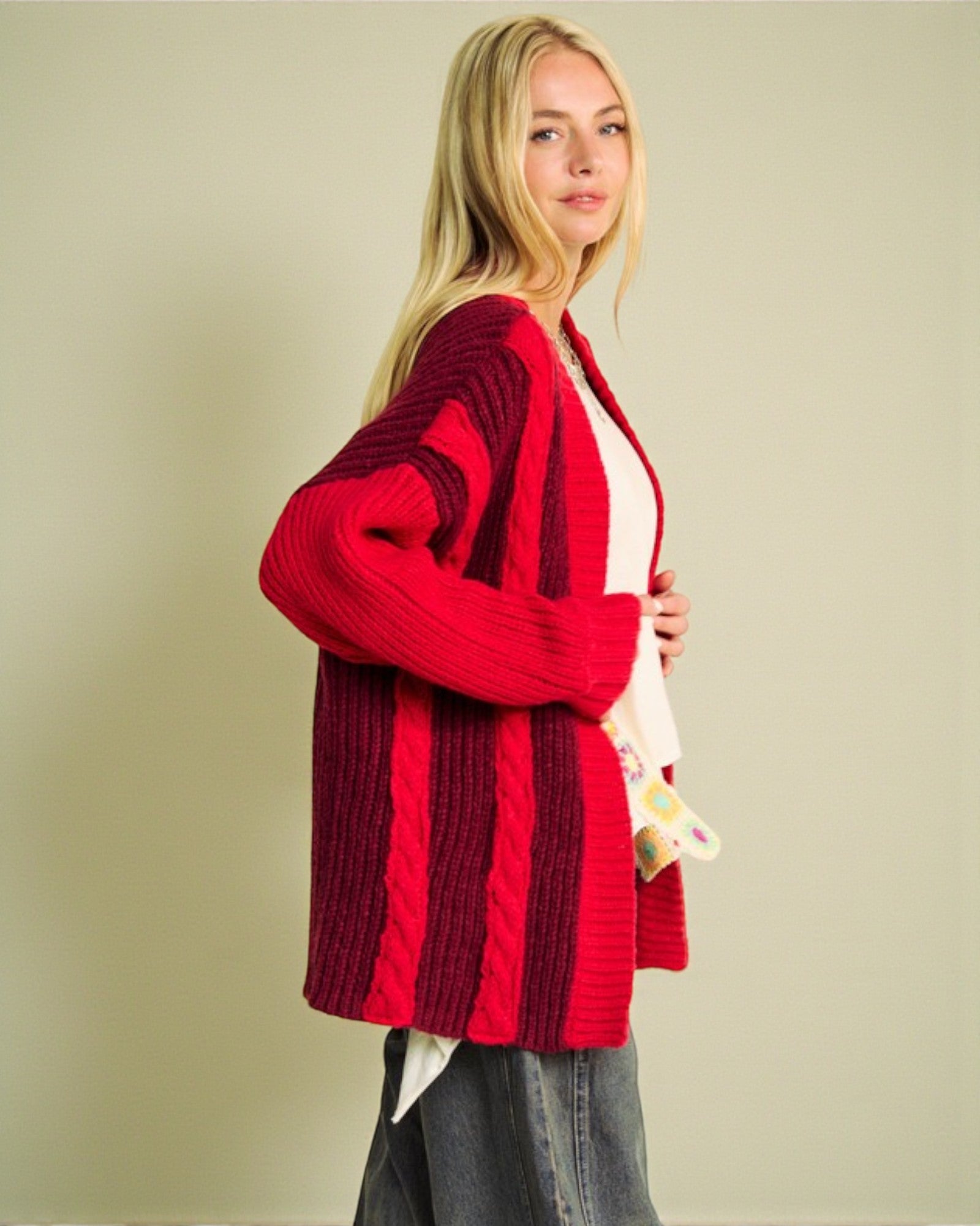 Woman wearing a red cardigan against a beige background