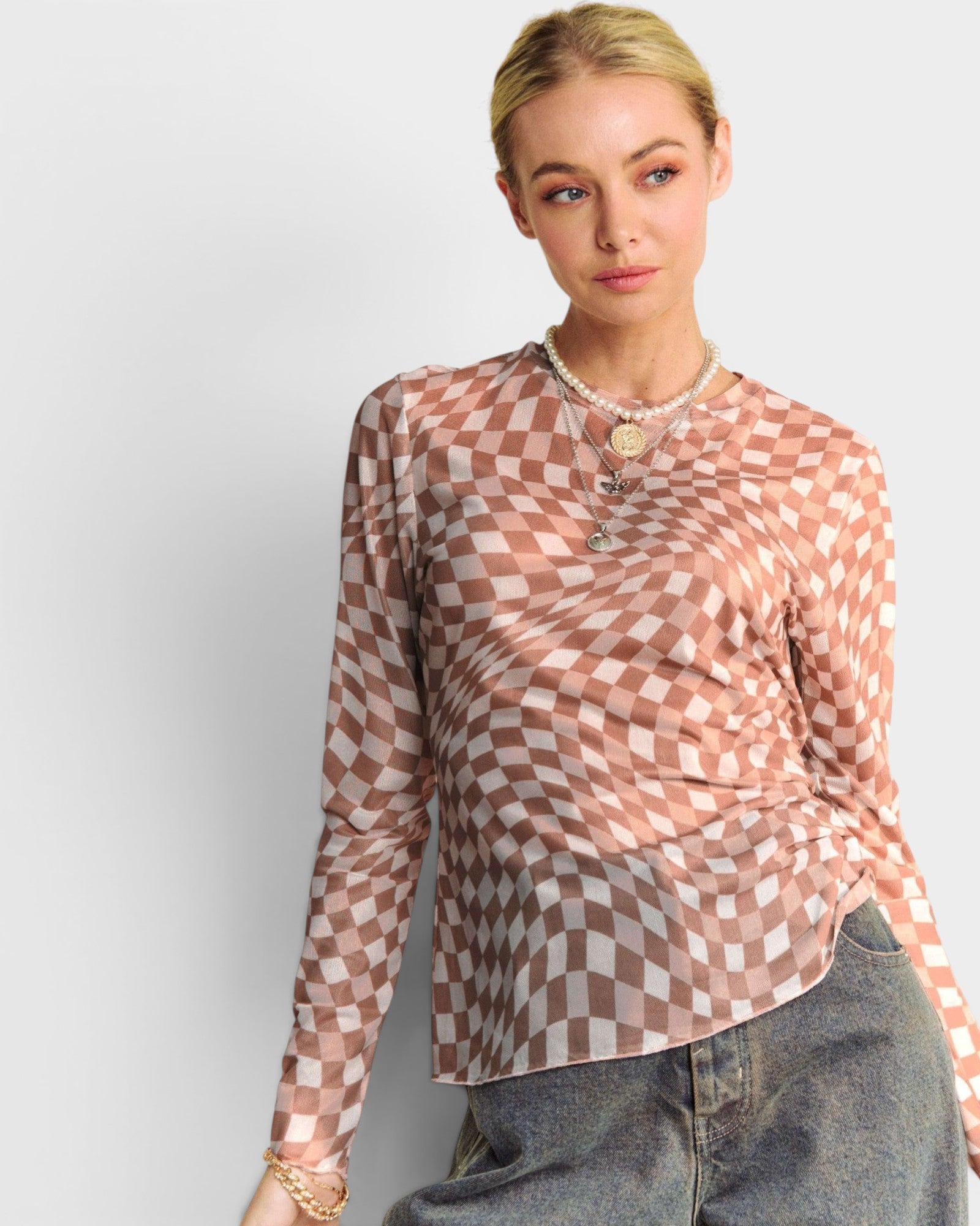 Woman wearing a checkered blouse with a plain background