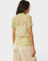 Woman wearing a patterned shirt with a plain background