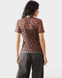 Woman wearing a brown and black checkered top with gray pants on a white background