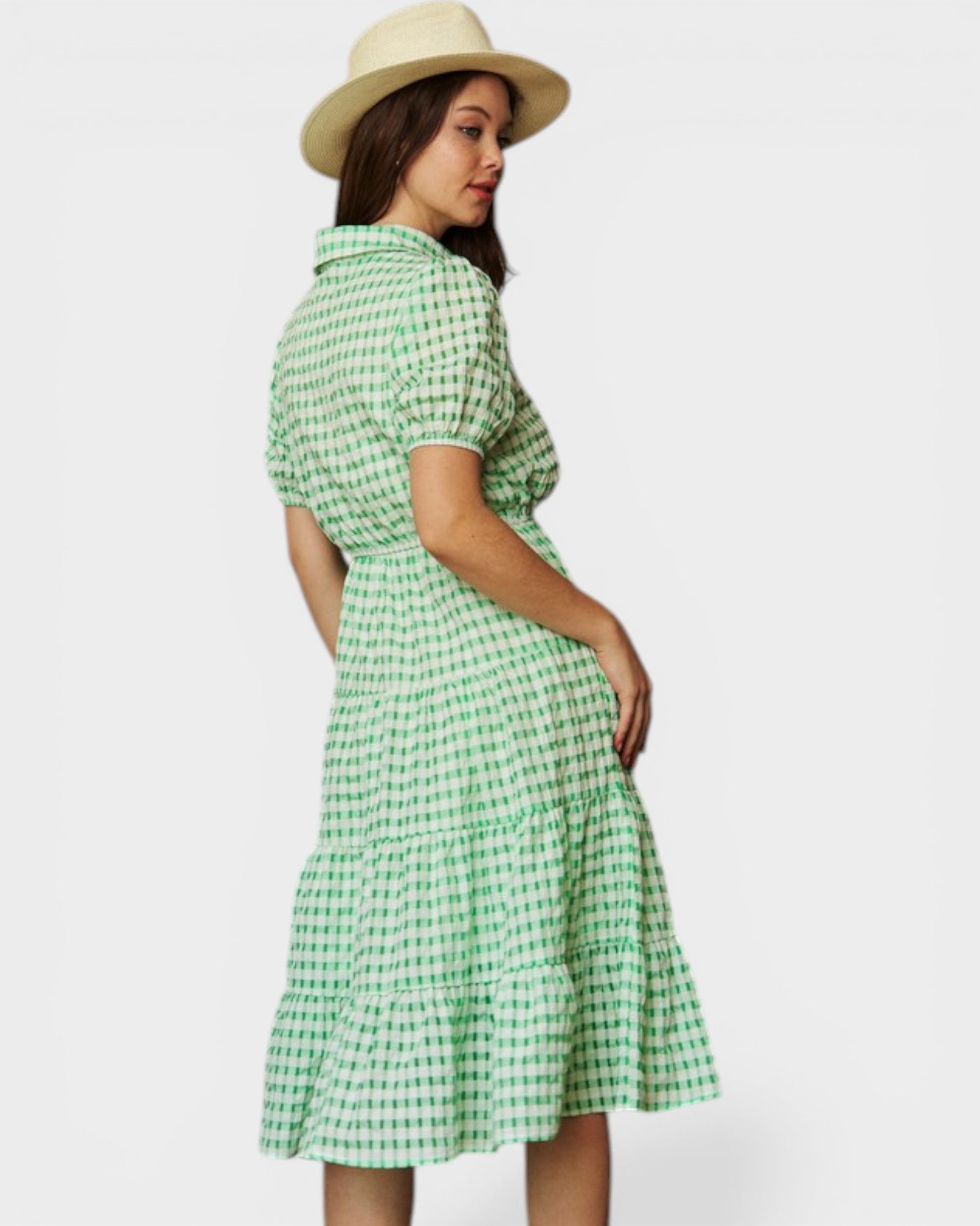 Woman wearing a green checkered dress and hat on a white background