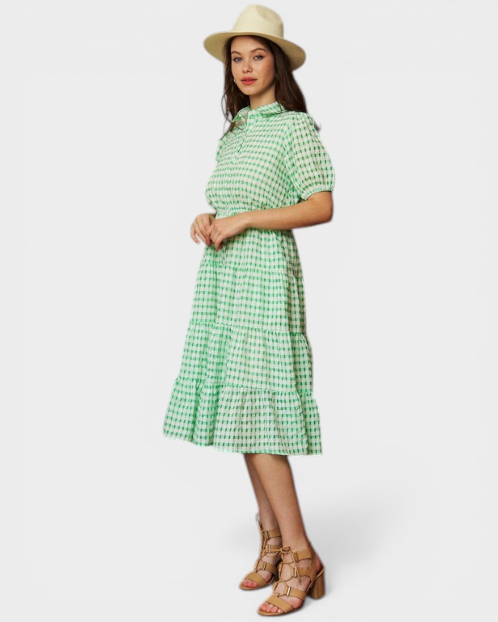 Woman wearing a green checkered dress and hat on a white background
