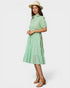 Woman wearing a green checkered dress and hat on a white background