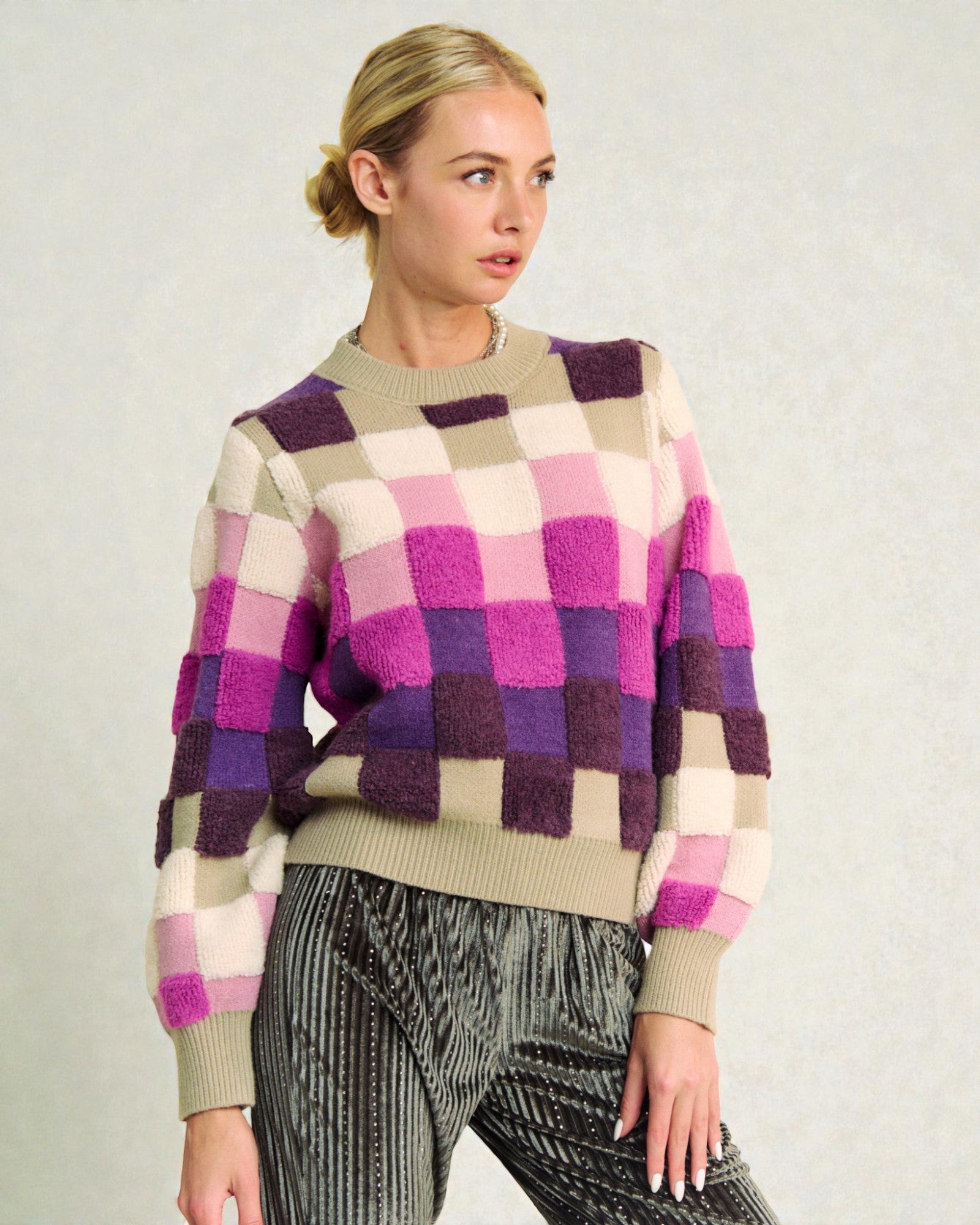 Woman wearing a checkered sweater with a neutral background