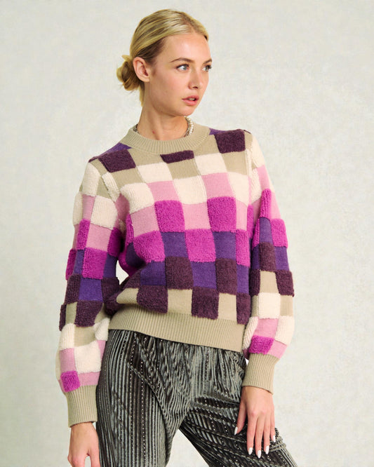 Woman wearing a checkered sweater with a neutral background
