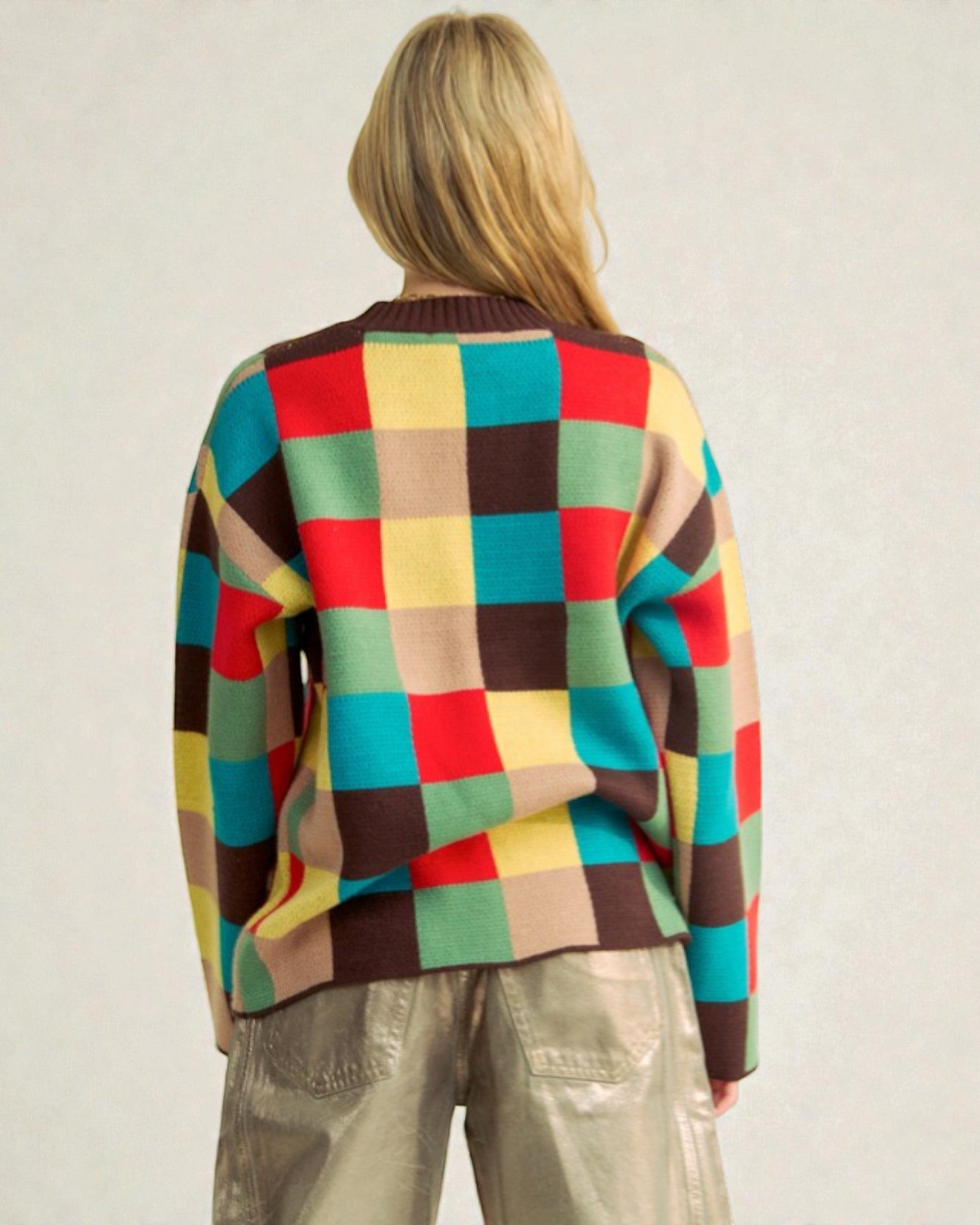 Person wearing a colorful checkered sweater against a plain background