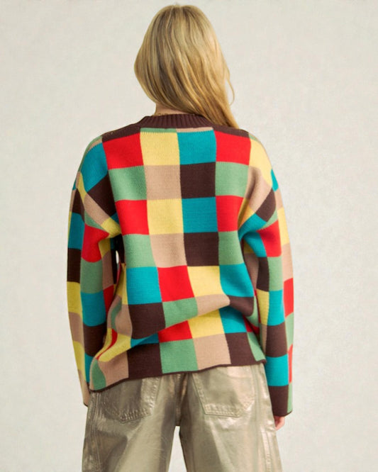 Person wearing a colorful checkered sweater against a plain background