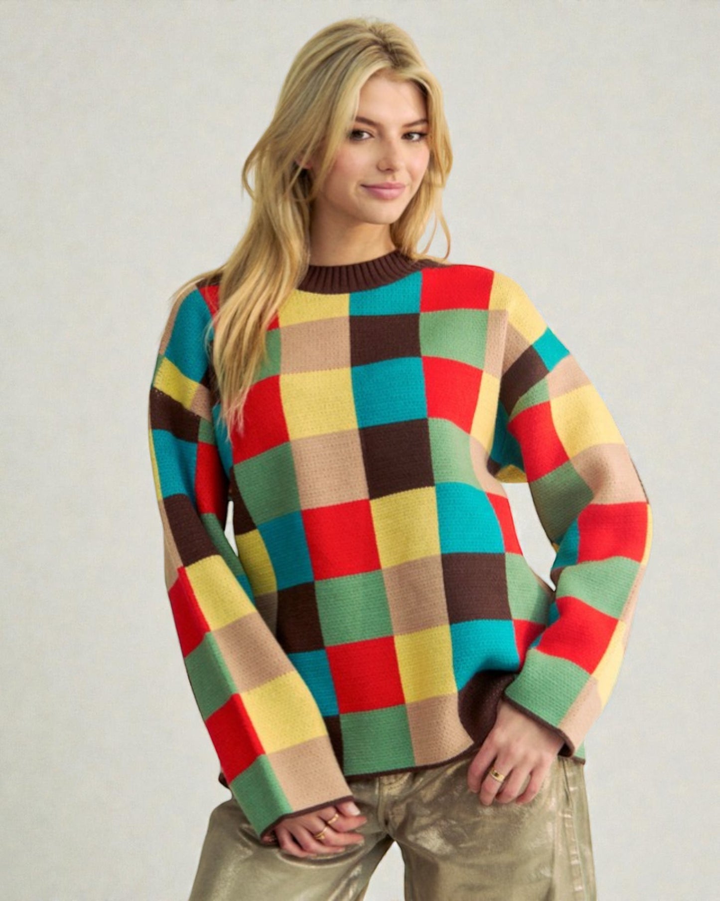 Woman wearing a colorful checkered sweater against a plain background