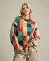 Woman wearing a colorful checkered sweater against a plain background