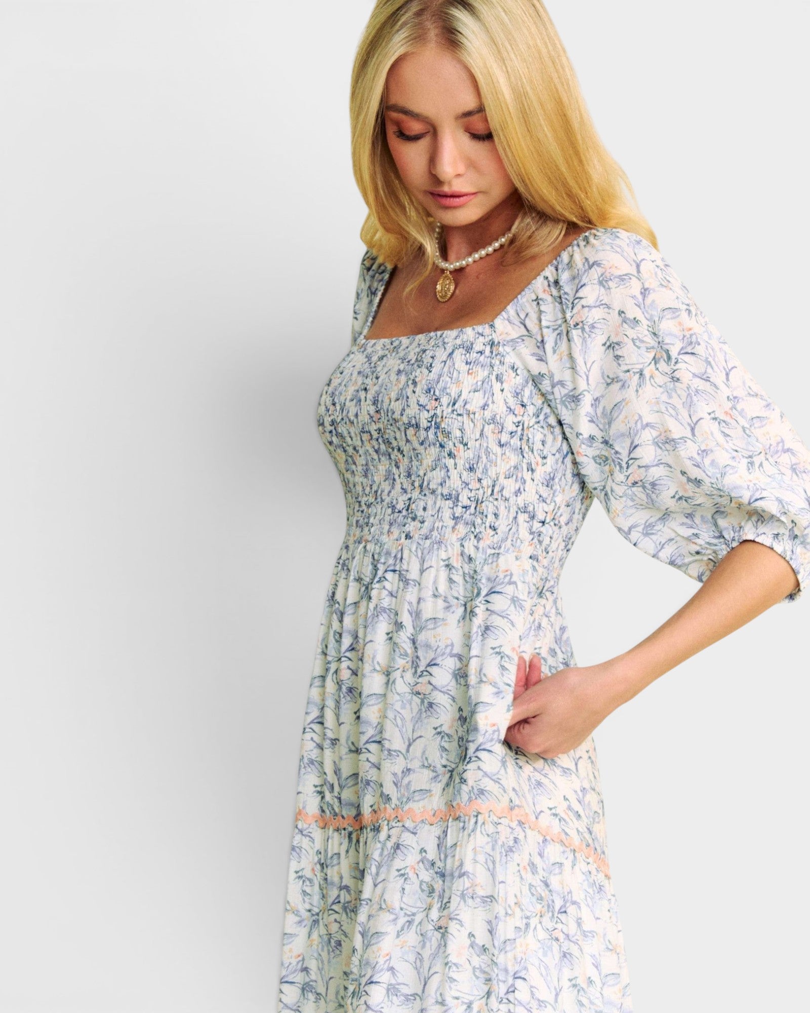 Woman wearing a floral dress with a plain background