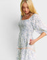 Woman wearing a floral dress with a plain background